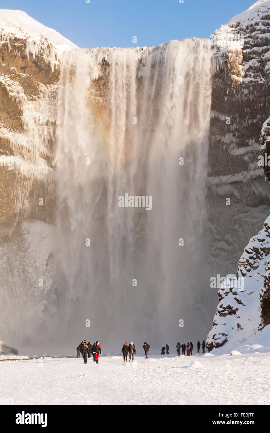 Grand groupe de touristes à la chute d'eau de Skogafoss, en Islande du Sud en janvier avec des icules congelés Banque D'Images