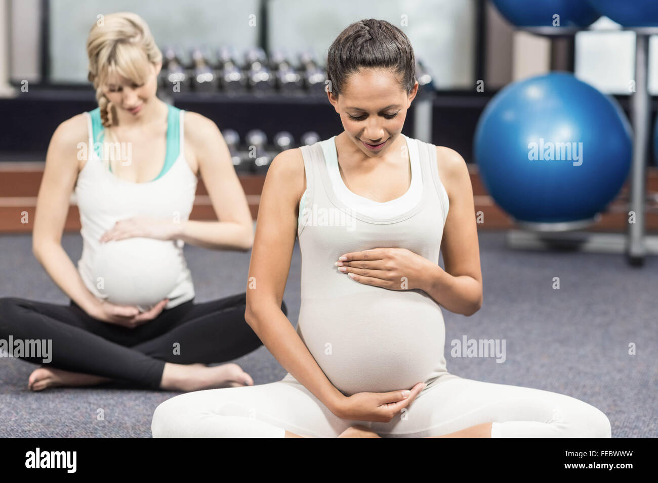 Les femmes enceintes souriant de toucher leur ventre Banque D'Images