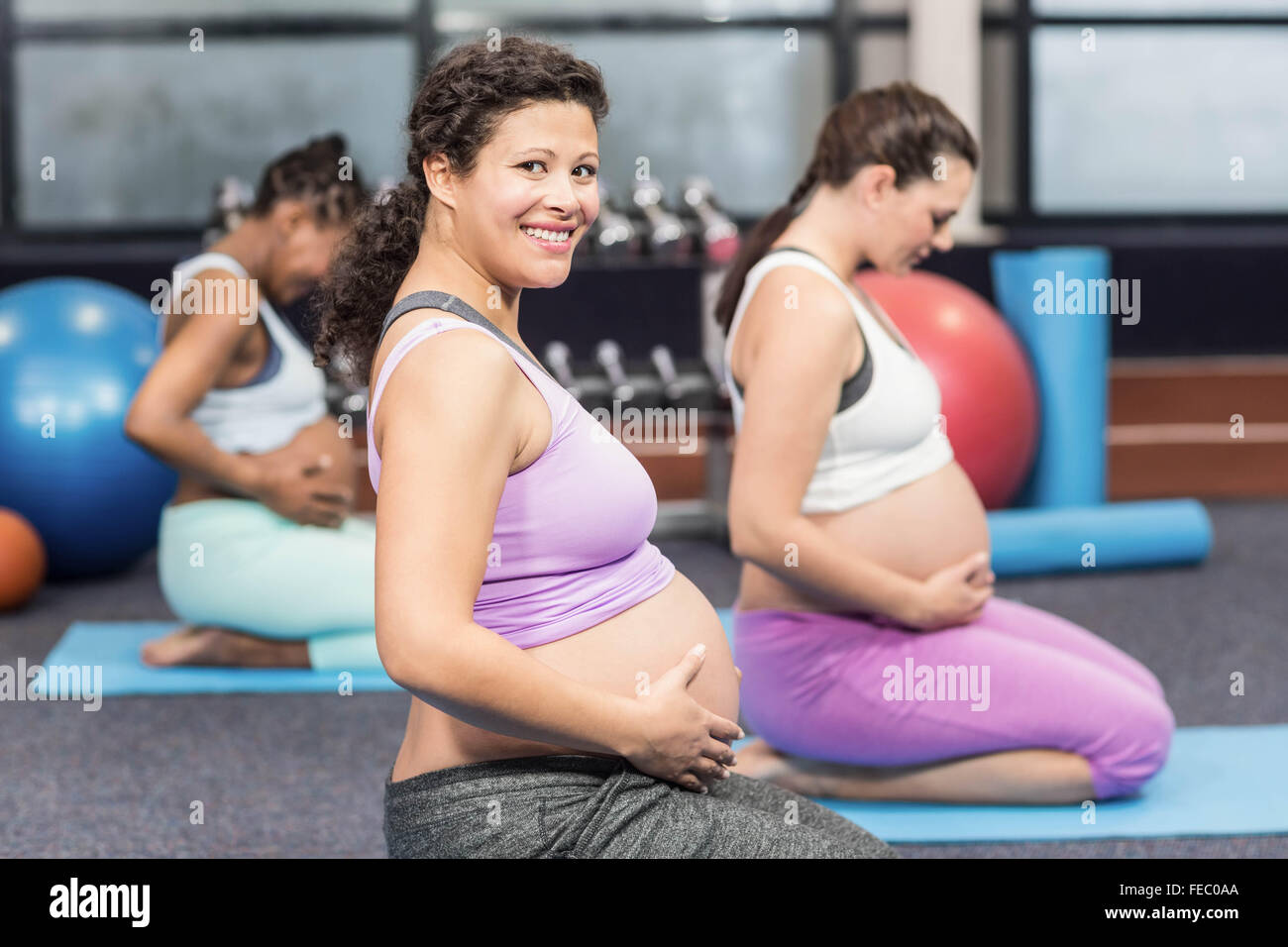 Les femmes enceintes faisant l'exercice sur mat Banque D'Images