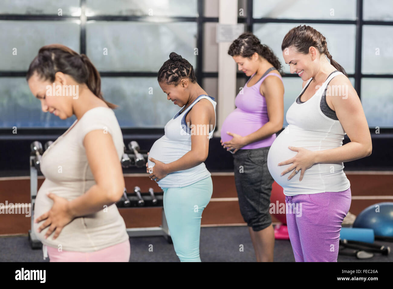 Les femmes enceintes souriant de toucher leur ventre Banque D'Images