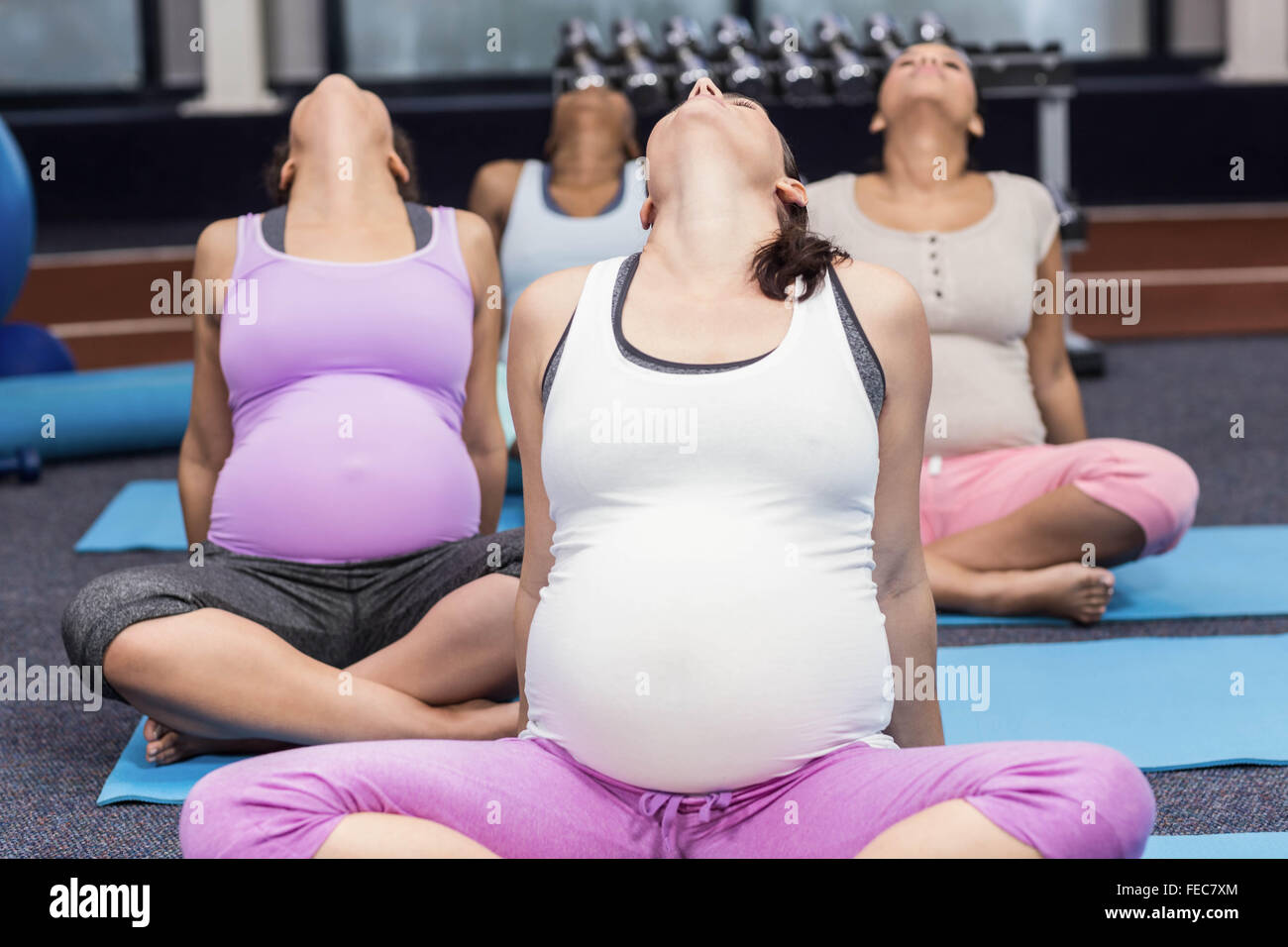 Les femmes enceintes faisant l'exercice de yoga Banque D'Images