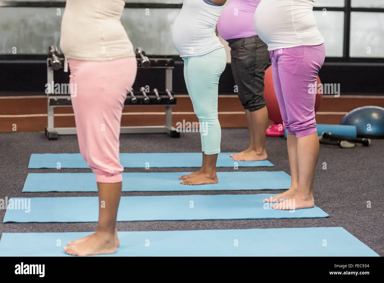 Les femmes enceintes faisant l'exercice sur mat Banque D'Images