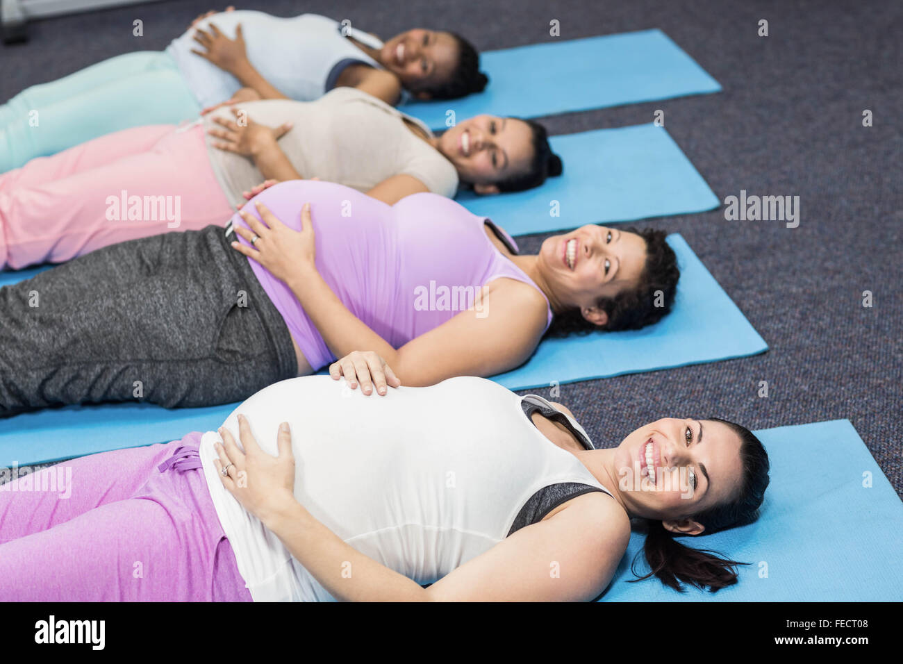 Les femmes enceintes se trouvant sur tapis d'exercice Banque D'Images