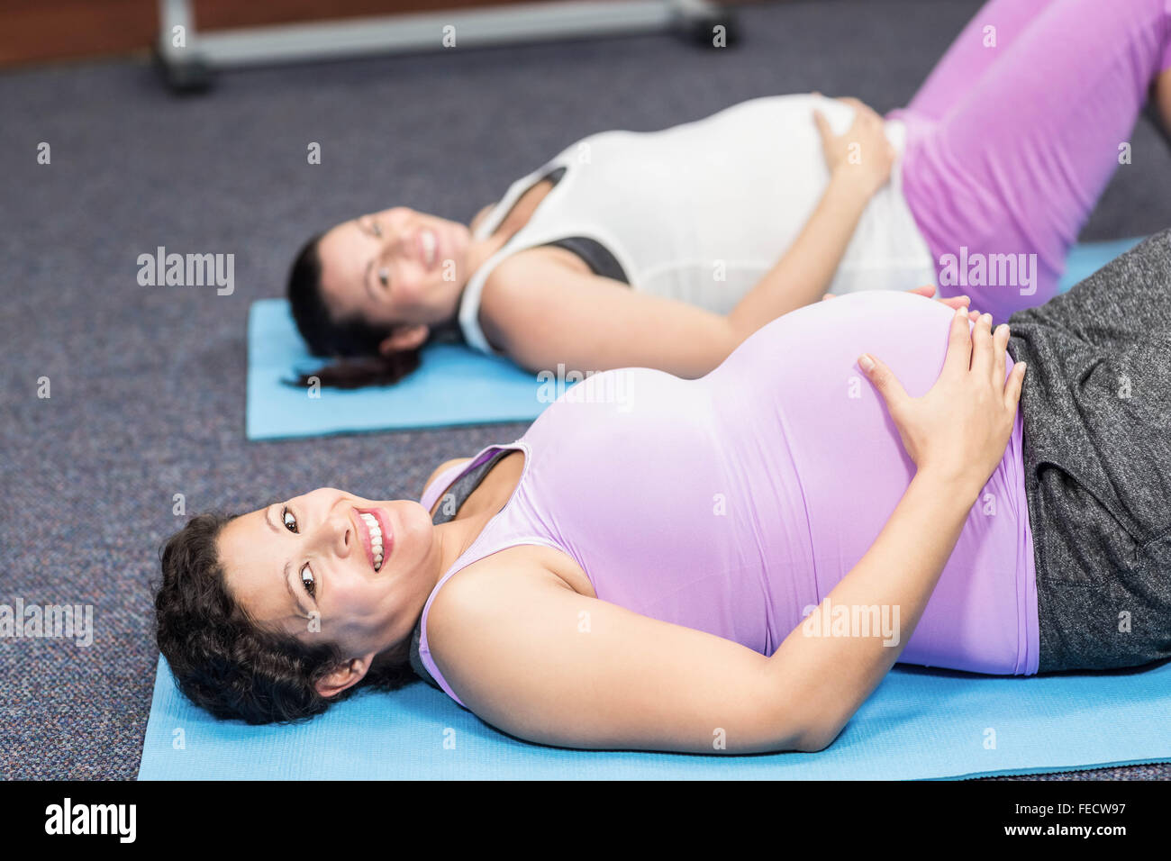 Les femmes enceintes se trouvant sur tapis d'exercice Banque D'Images
