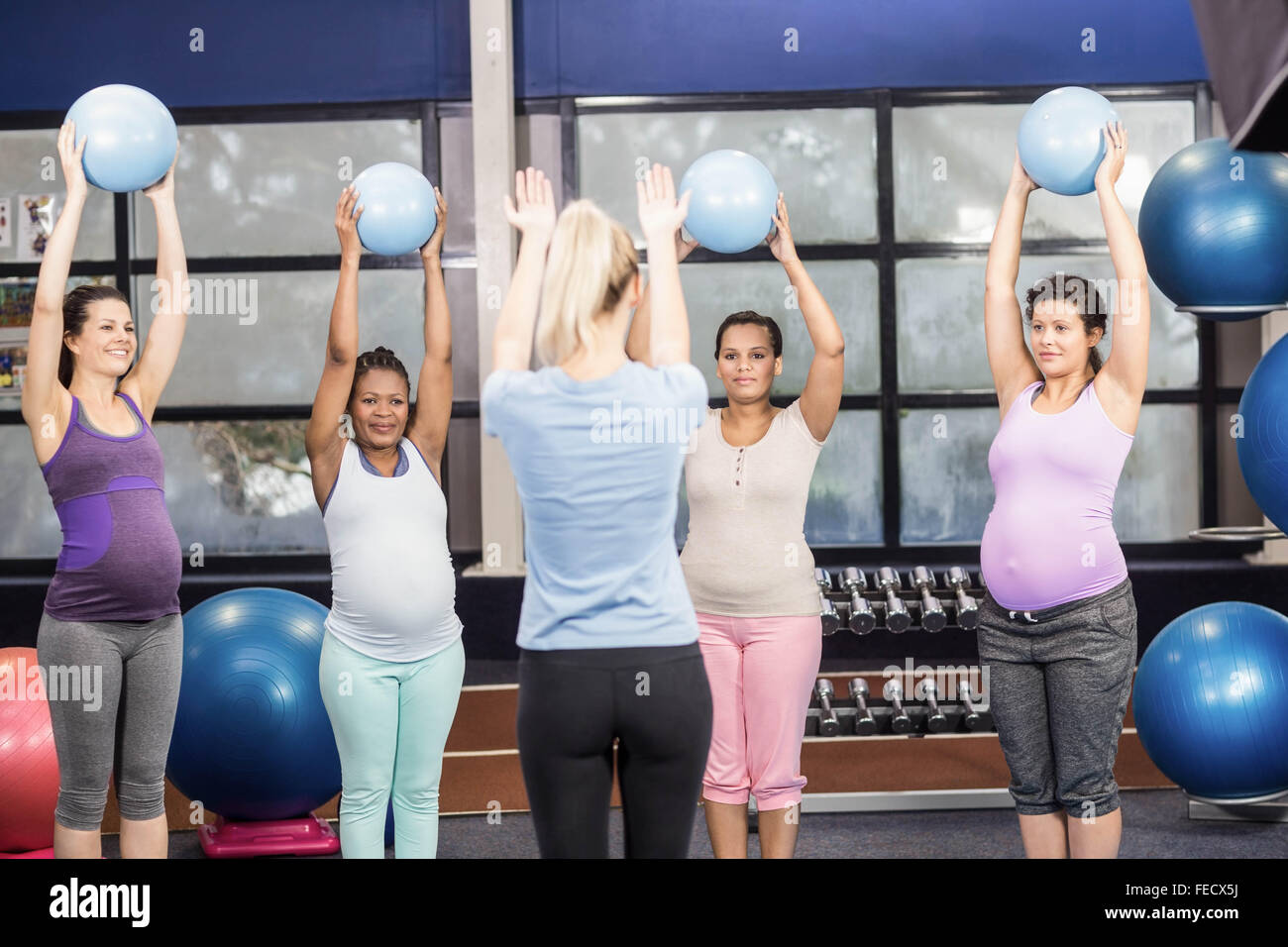 Les femmes enceintes et formateur exerçant avec fitness ball Banque D'Images