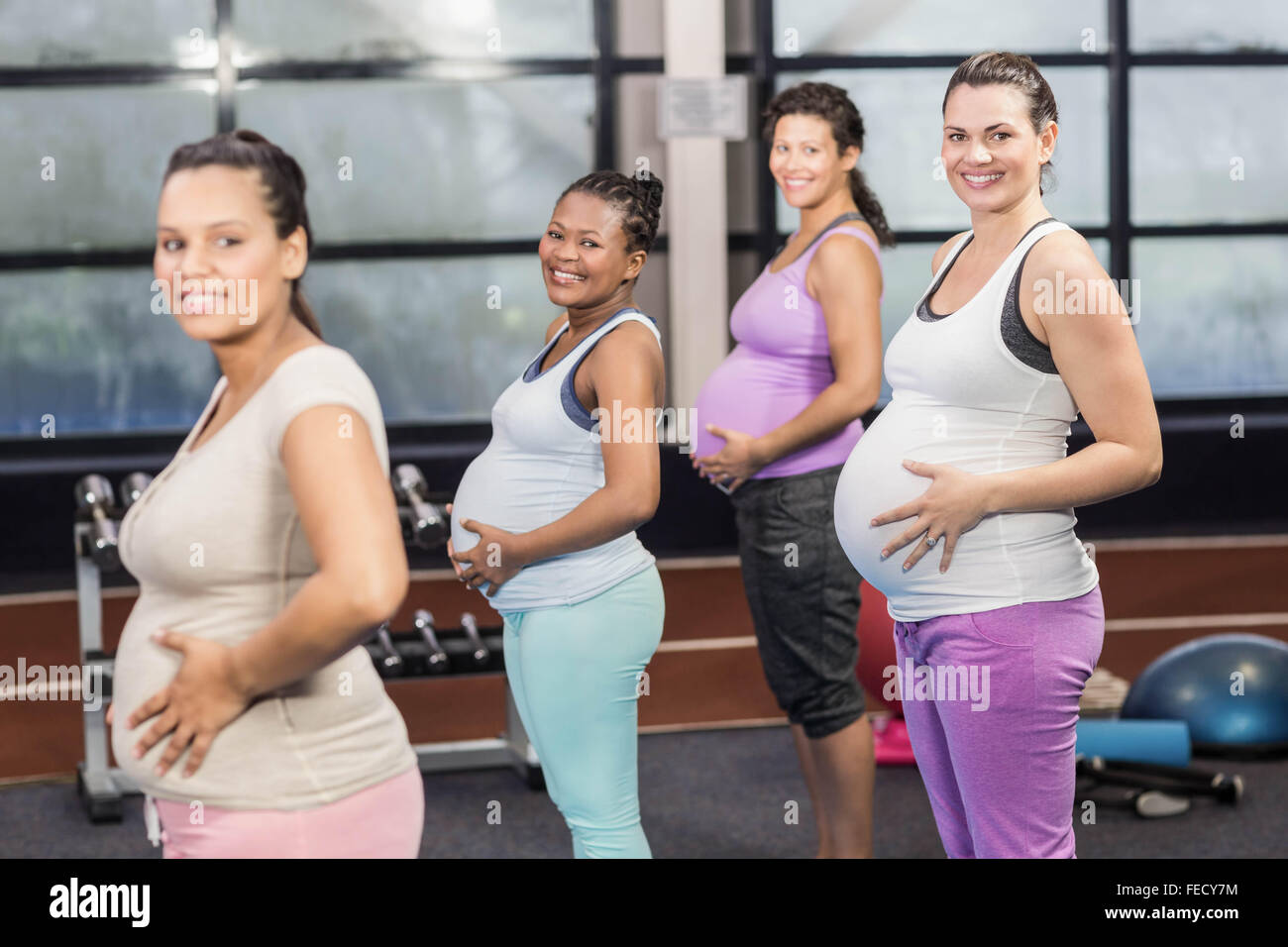 Les femmes enceintes souriant de toucher leur ventre Banque D'Images