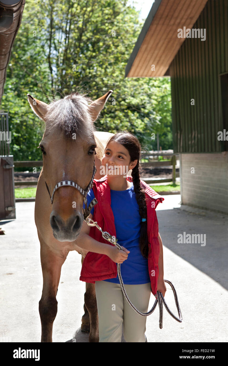 Petite fille avec son poney favori à l'extérieur Banque D'Images