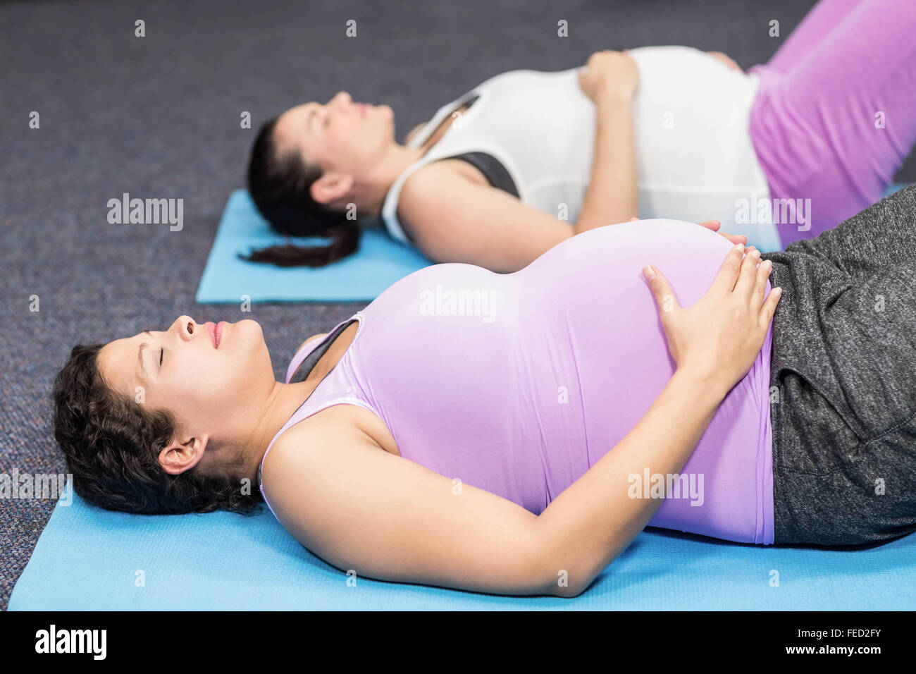 Les femmes enceintes se trouvant sur tapis d'exercice Banque D'Images
