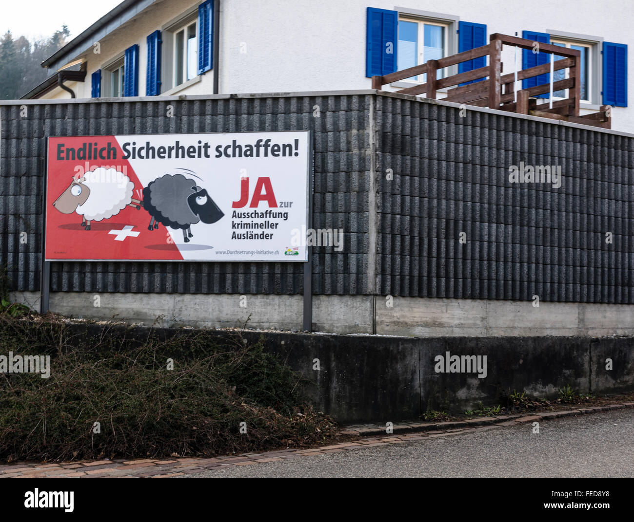 Affiche de campagne d'un référendum "pour le renvoi des criminels étrangers efficace' est suspendu à un mur dans les régions rurales de la Suisse. Banque D'Images