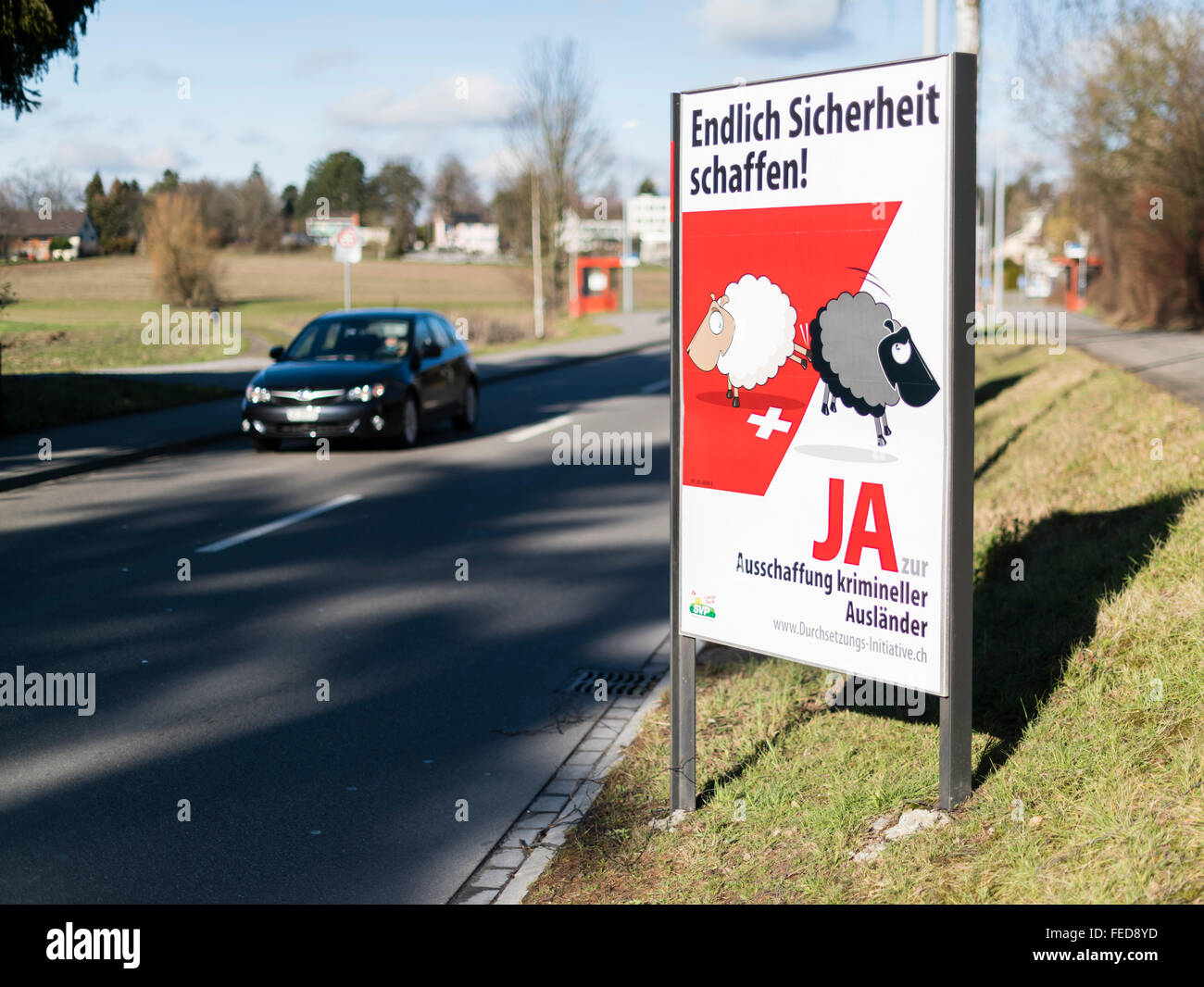 Affiche de campagne d'un référendum "pour le renvoi des criminels étrangers efficace' à côté d'une rue dans les régions rurales de la Suisse. Banque D'Images