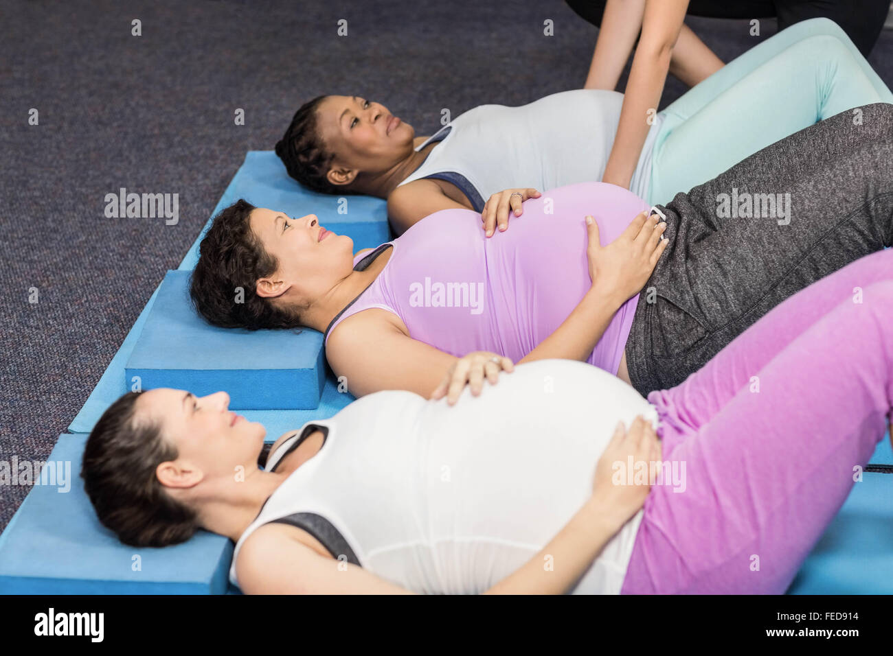 Les femmes enceintes se trouvant sur tapis d'exercice Banque D'Images