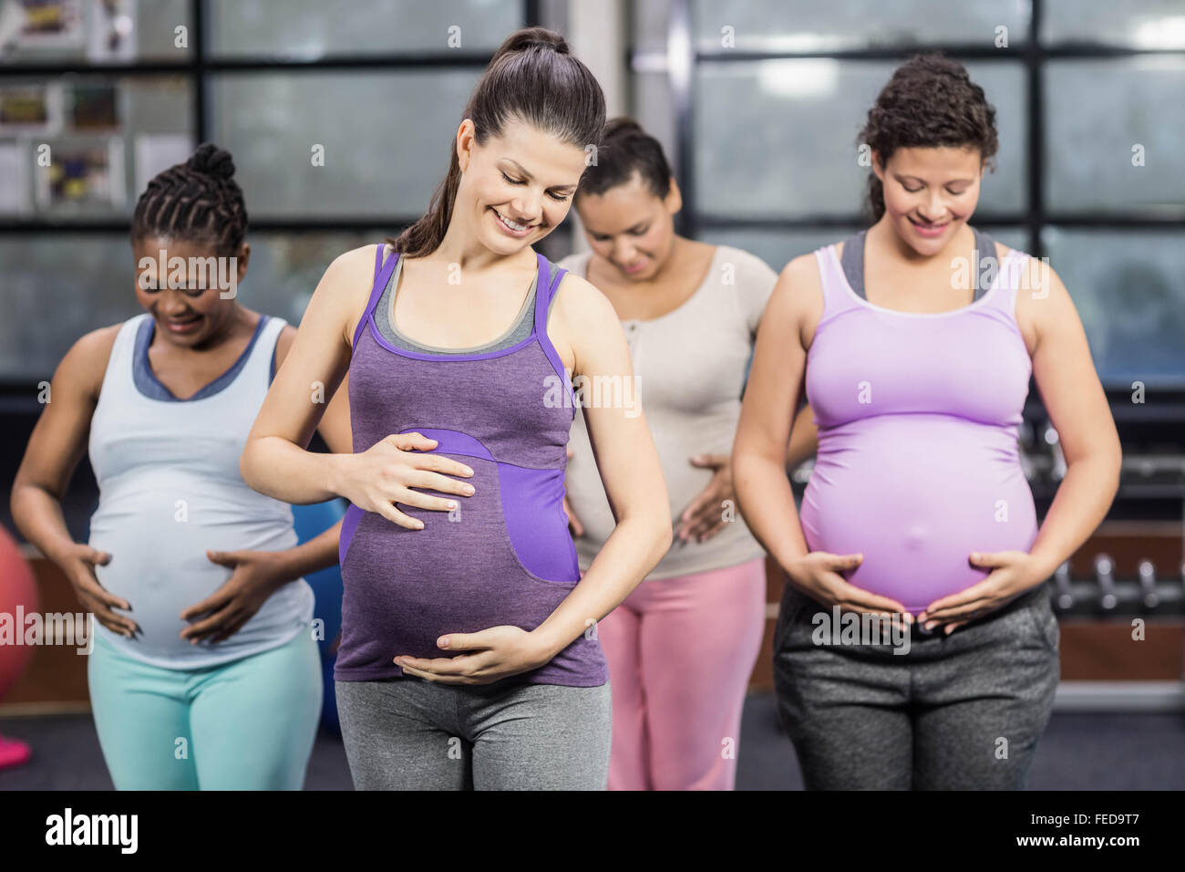 Les femmes enceintes souriant de toucher leur ventre Banque D'Images