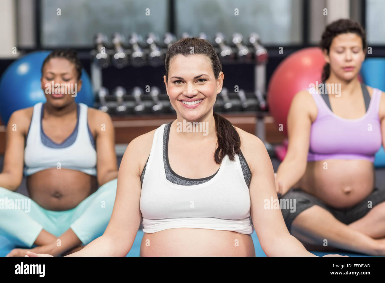 Cheerful femmes enceintes yoga mats Banque D'Images
