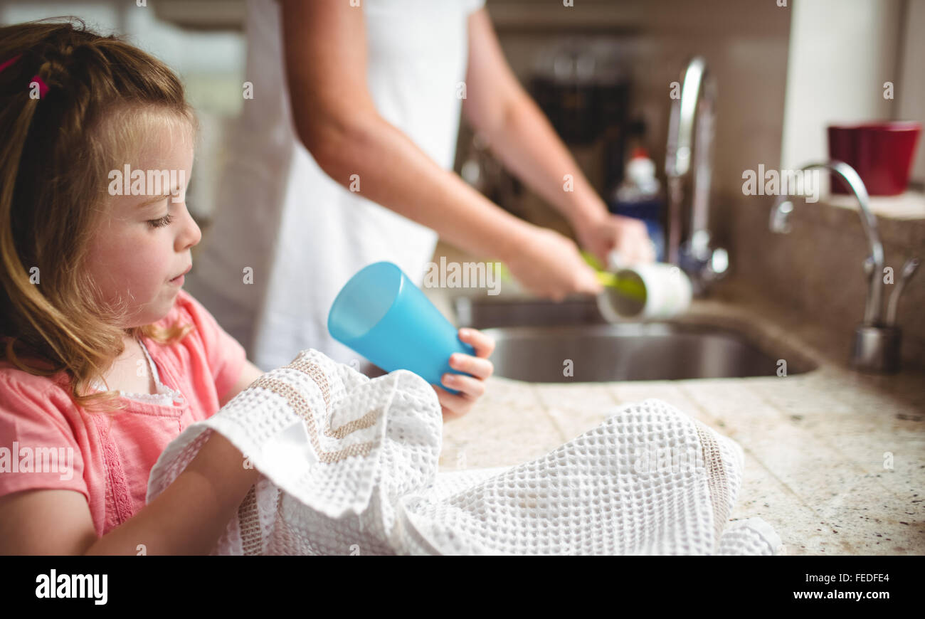Fille d'aider sa mère lave la vaisselle Banque D'Images