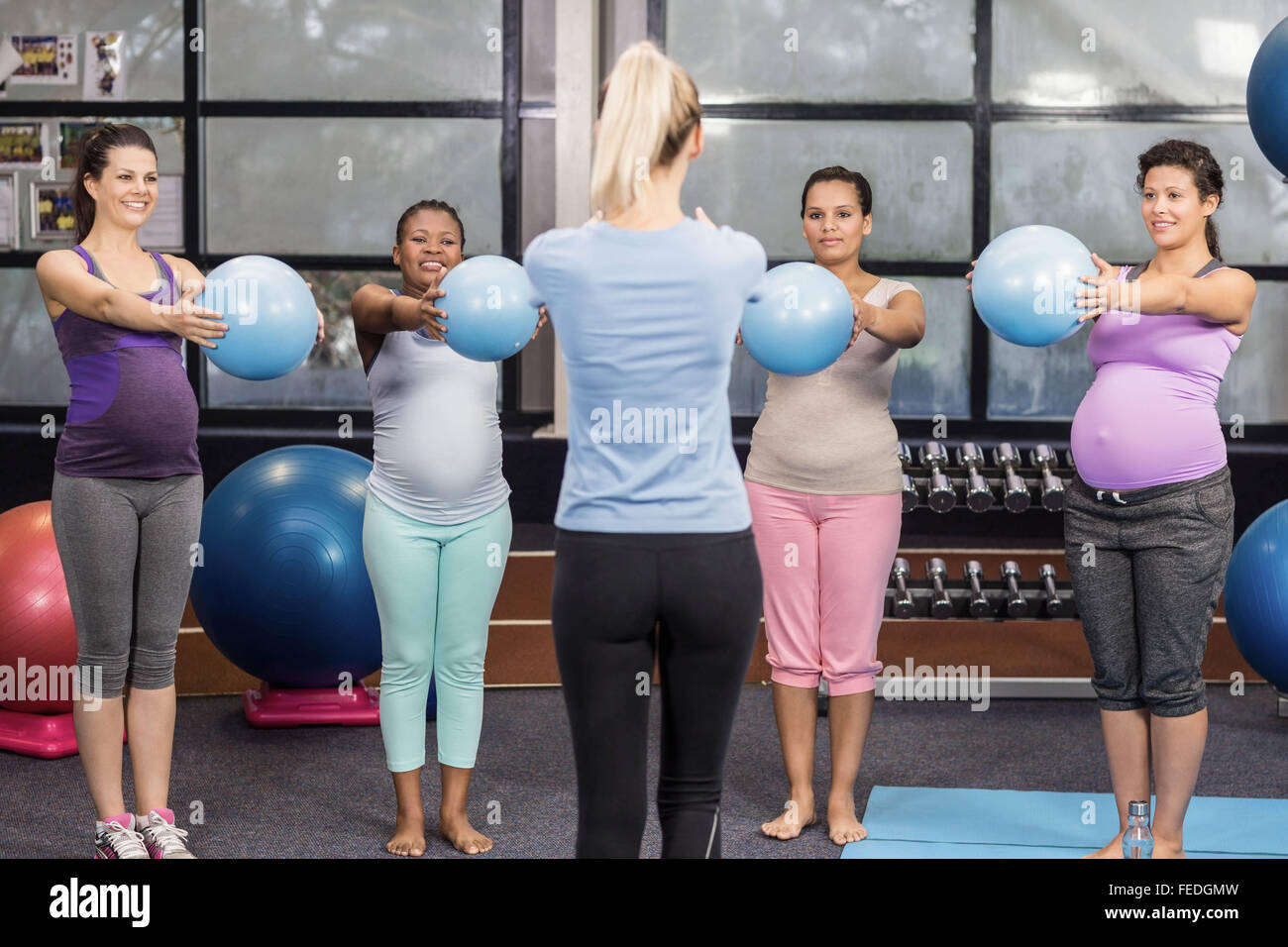 Les femmes enceintes et formateur exerçant avec fitness ball Banque D'Images