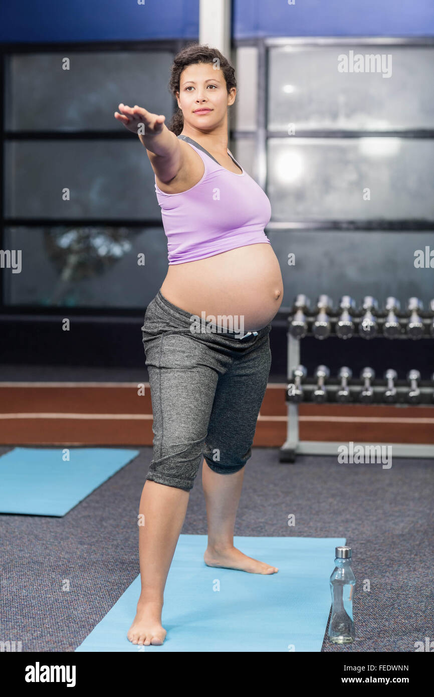 Les femmes enceintes faisant l'exercice sur mat Banque D'Images