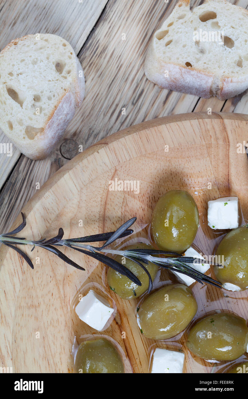 Olive verte farcie de fromage feta sur planche de bois. Banque D'Images