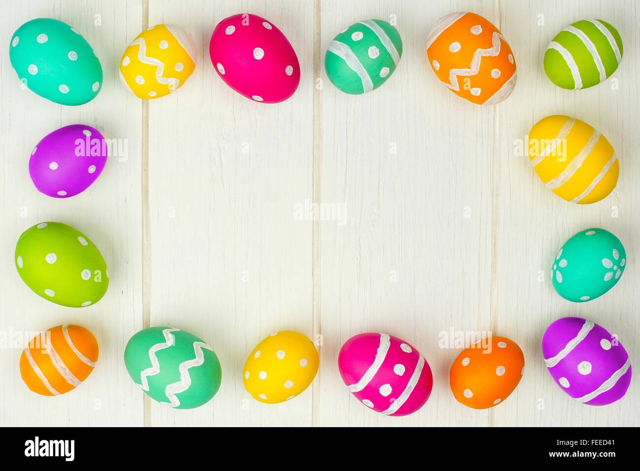 Oeufs de Pâques colorés à l'encontre d'une trame de fond en bois blanc Banque D'Images