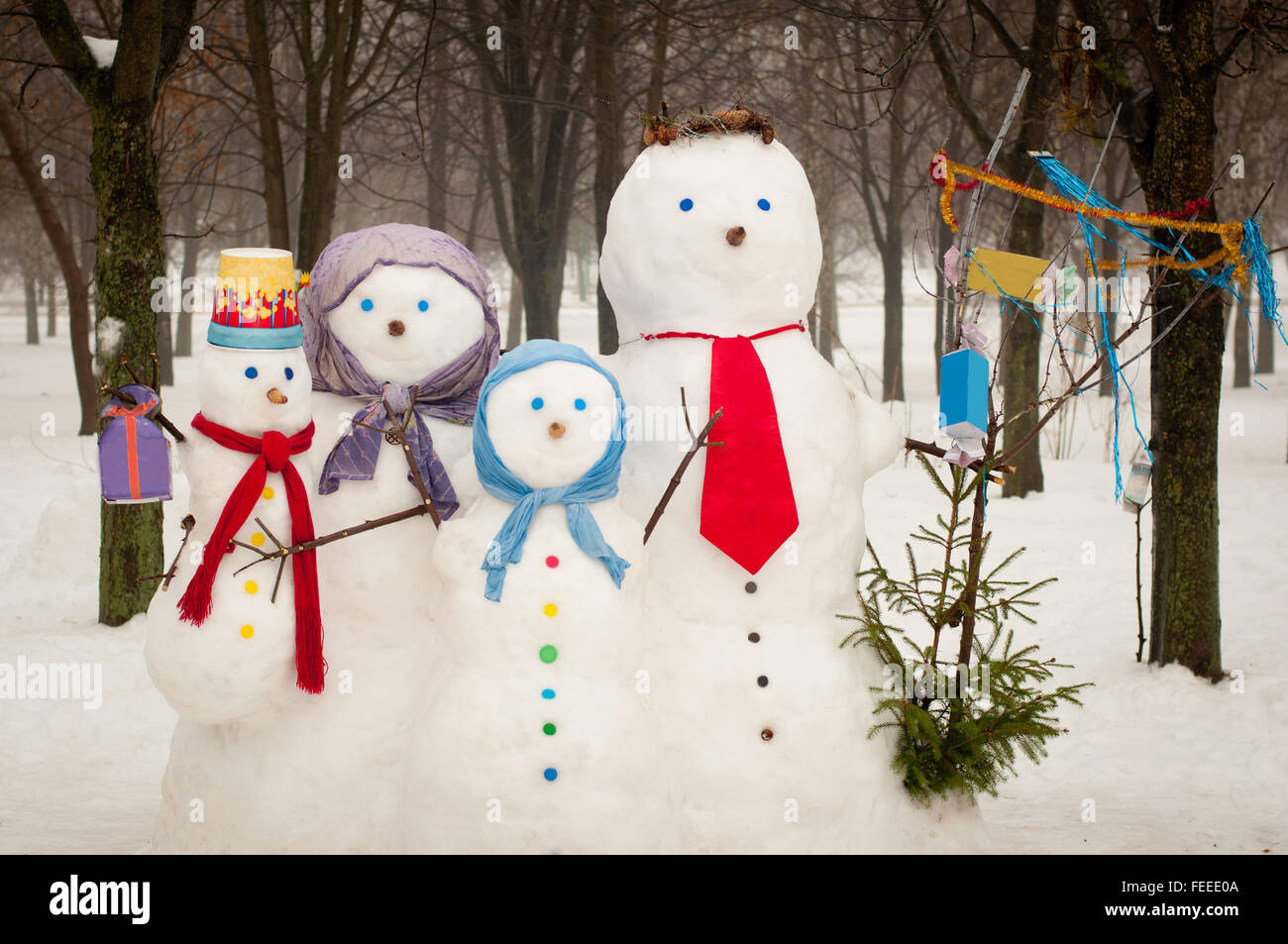 Famille de quatre bonhommes de neige à l'extérieur en hiver Banque D'Images