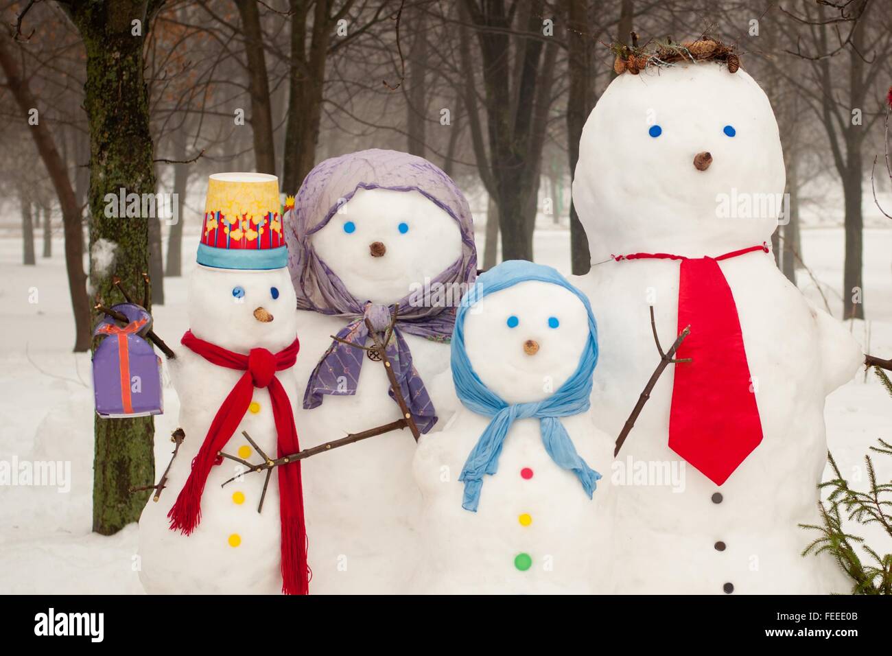 Famille de quatre bonhommes de neige à l'extérieur en hiver Banque D'Images