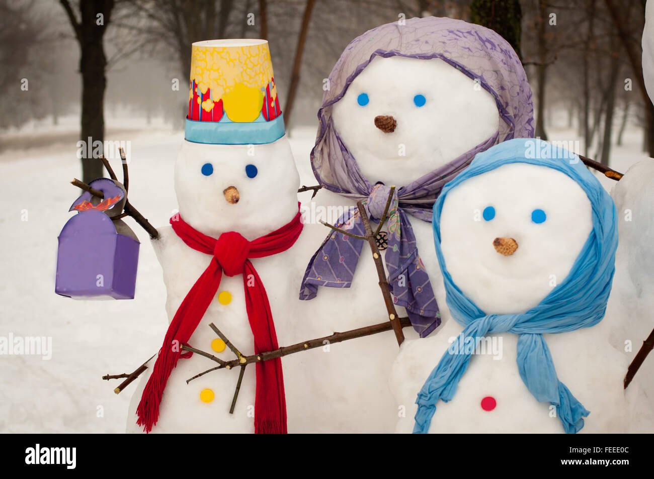 Famille de trois bonhommes de neige à l'extérieur en hiver Banque D'Images