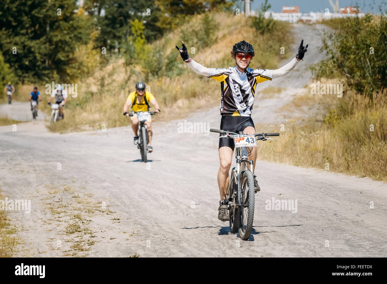 Les cyclistes du groupe en vtt équitation à jour ensoleillé. Cycliste avec les mains levées jusqu'au premier plan. Compétition sportive, active. Banque D'Images