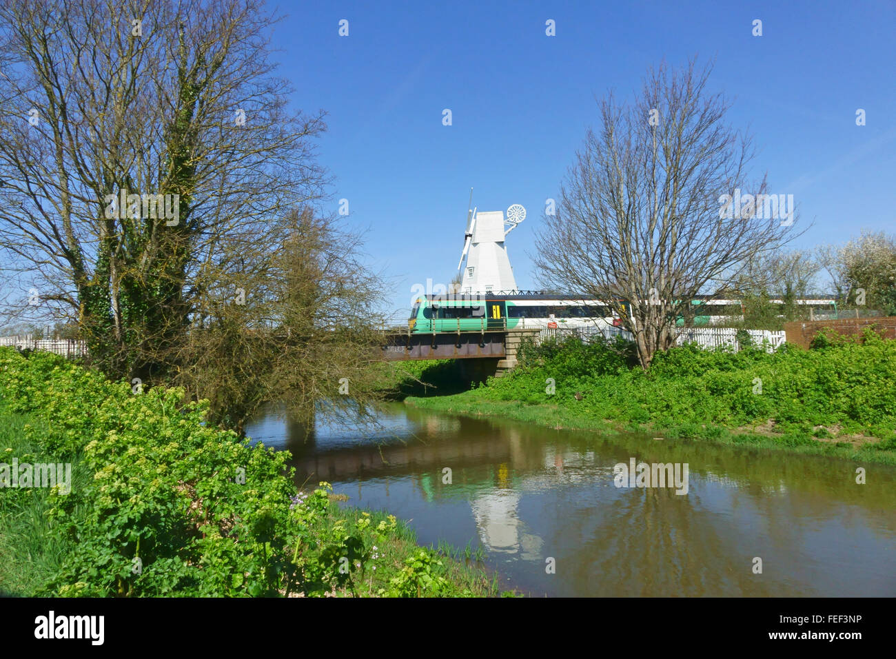 Train électrique du sud-est traversant le pont sur la rivière Tillingham juste à l'extérieur de la gare de Rye par le moulin à vent, East Sussex, Angleterre, Royaume-Uni, GB Banque D'Images