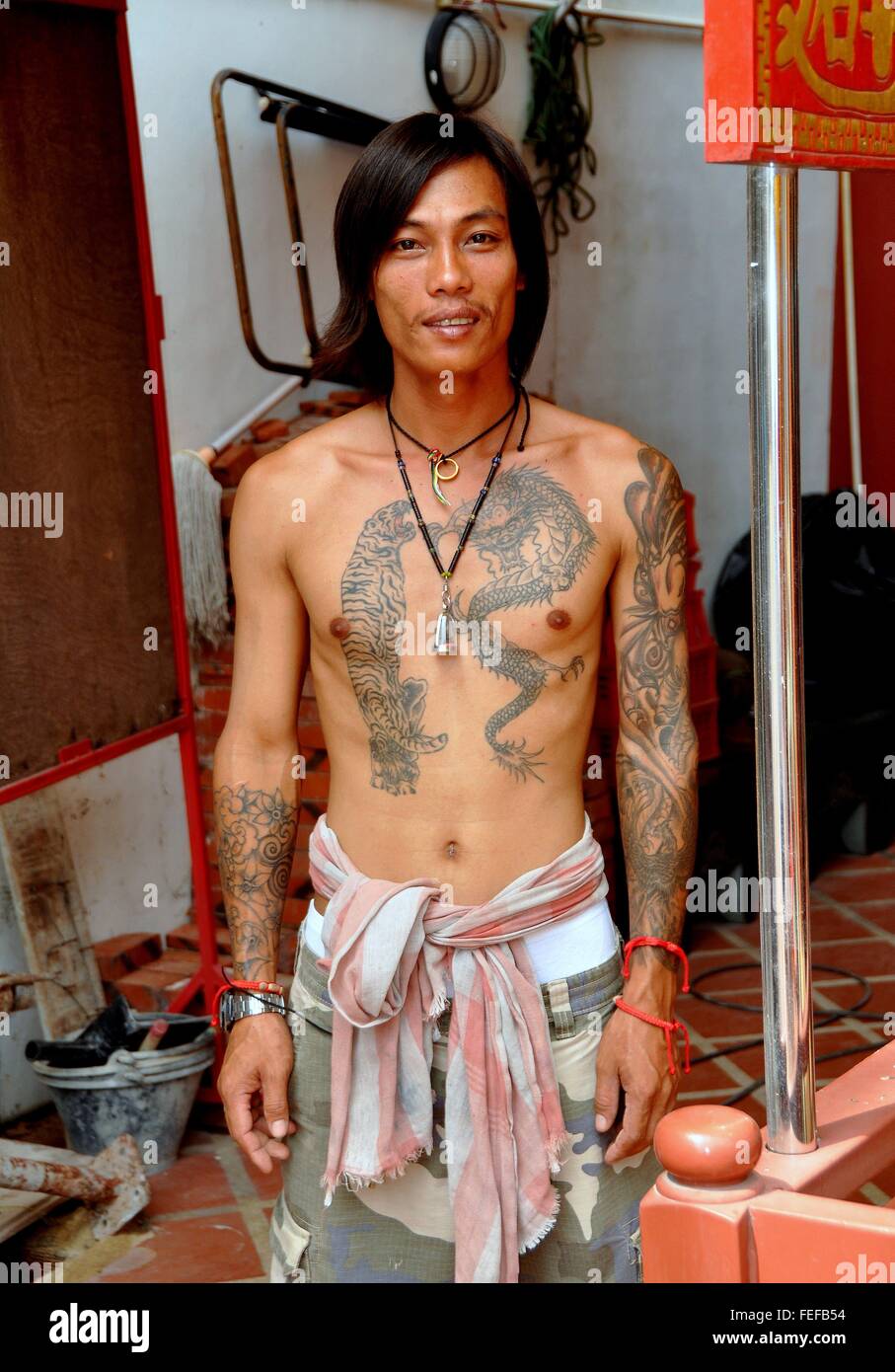 La ville de Phuket, Thaïlande : Thai ouvrier de construction avec plusieurs tatouages sur sa poitrine et bras Banque D'Images