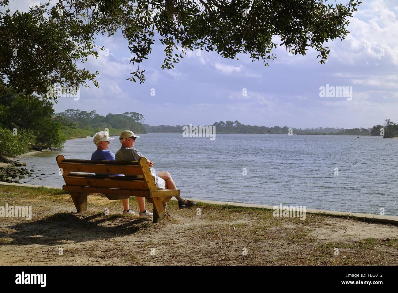 Couple assis sur un banc avec vue sur la rivière Matanzas, Kentucky Oaks Gardens State Park, Floride Banque D'Images