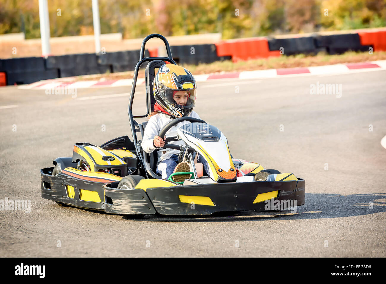 Petite fille est roulant Rendez- Kart voiture dans une aire racing track Banque D'Images