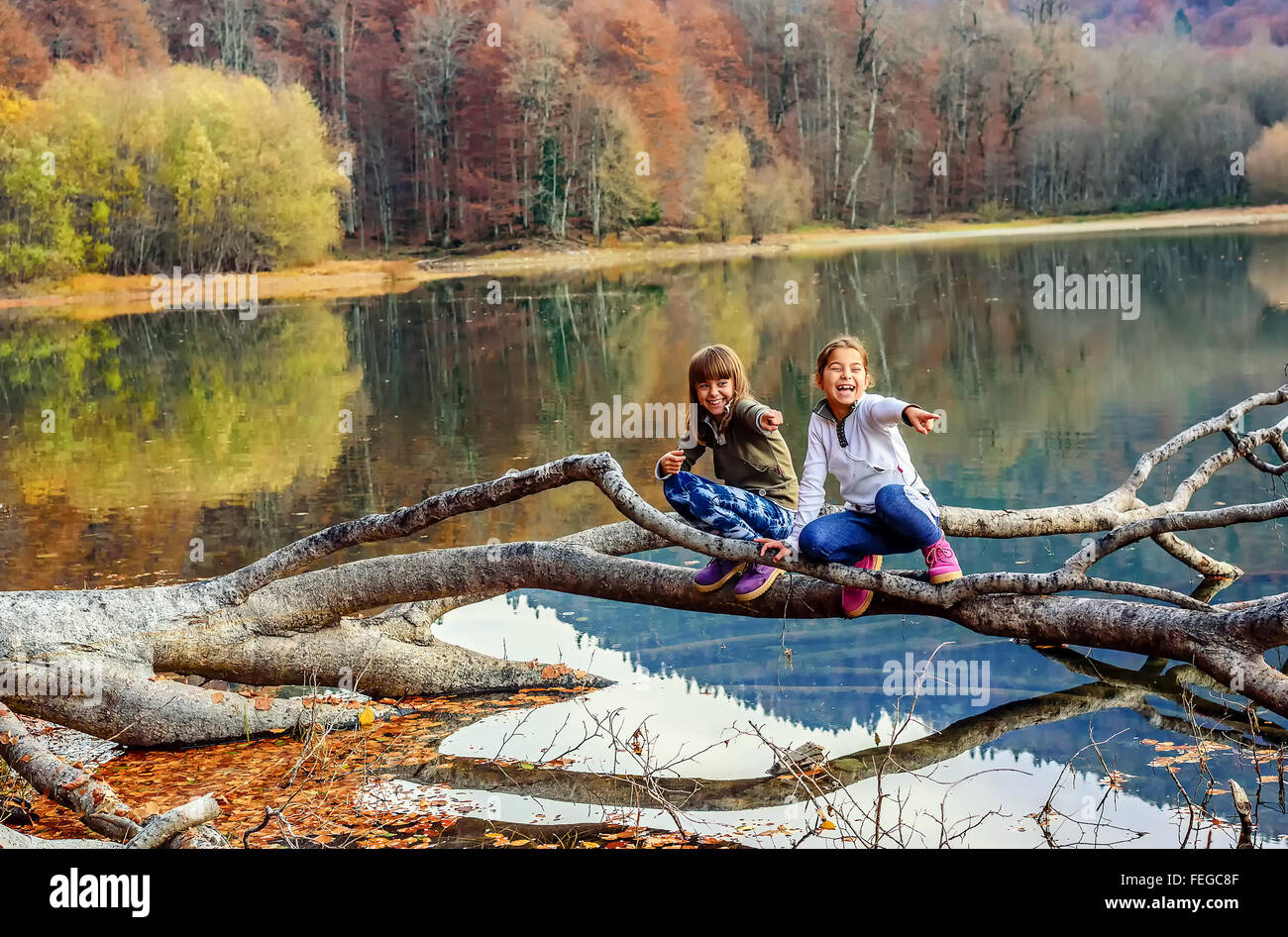 Deux petites filles rire et pointer du doigt sur le lac Biogradsko ezero (Biograd), parc national de Biogradska Gora en automne, Mont Banque D'Images
