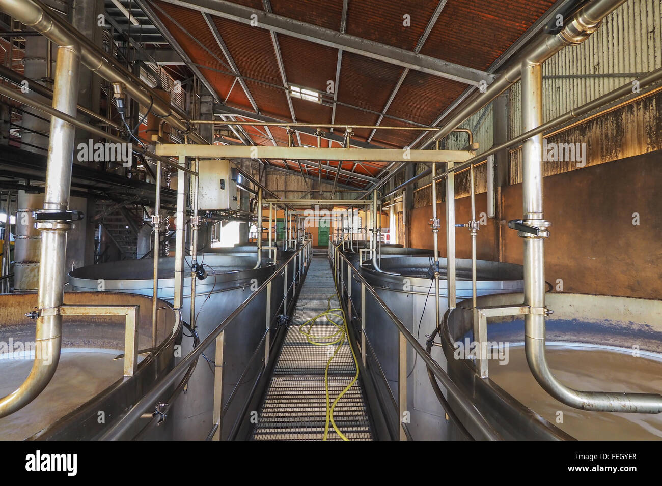 Vue intérieure d'une usine de rhum à Marie Galante, des Caraïbes, avec des réservoirs et tuyaux de brassage pour laisser le jus de sucre. fermentarion Banque D'Images