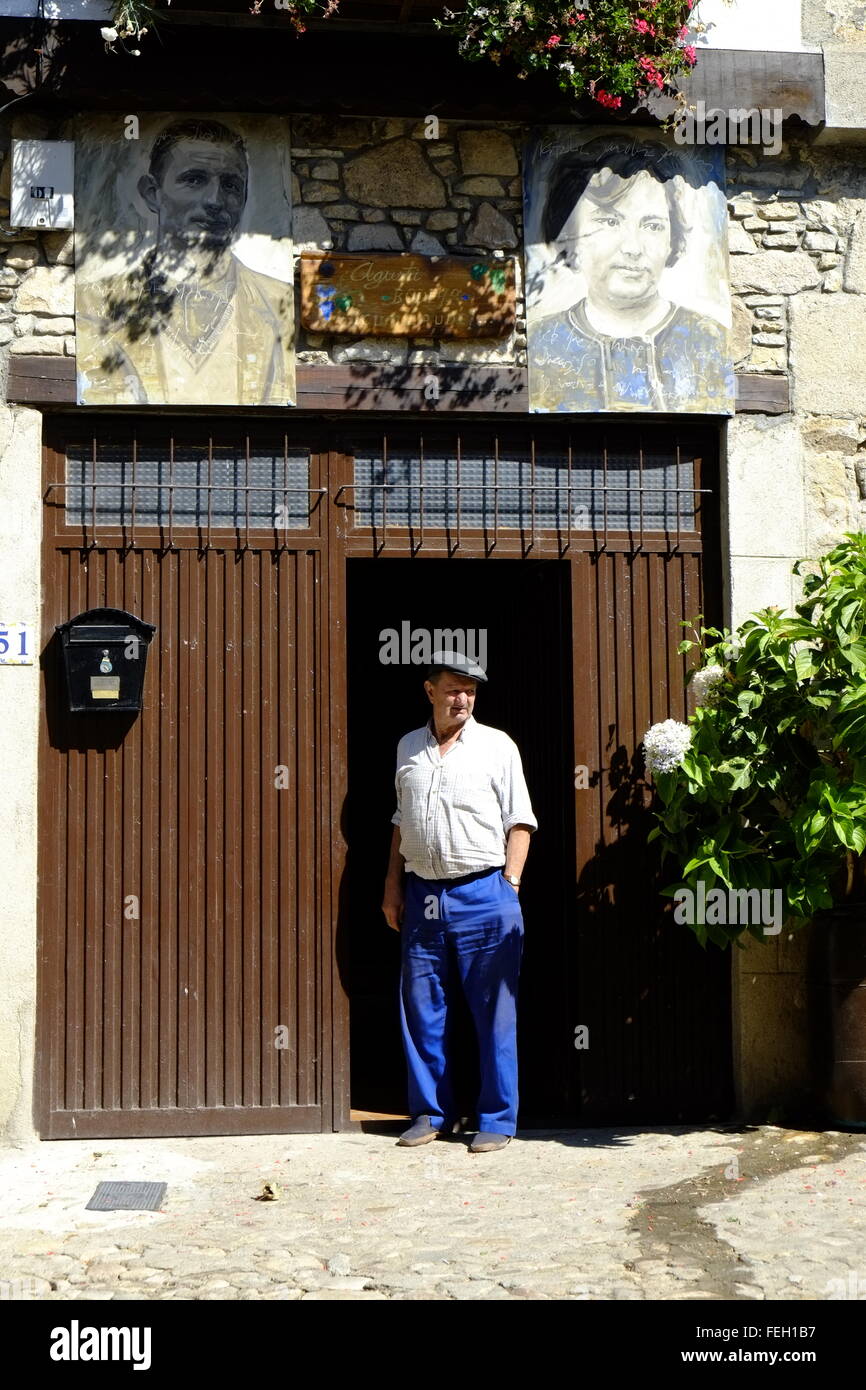 Householder se tenant devant sa maison de ville médiévale avec des portraits des habitants de leurs maisons. Mogarraz, Castilla y León. Espagne Banque D'Images