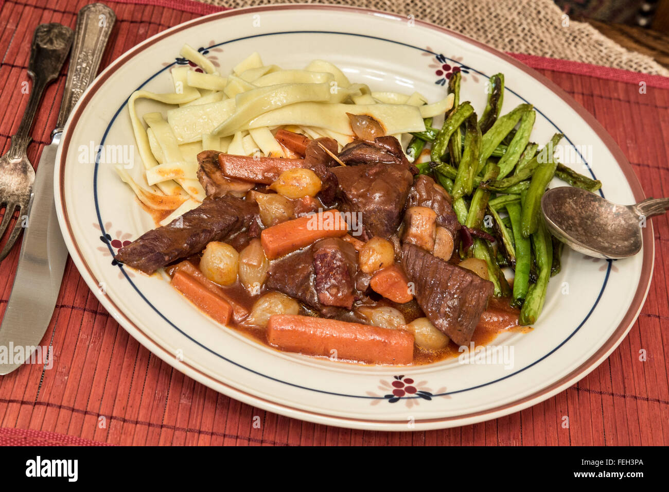 Assiette de la bière cœur bourguignon avec des nouilles et des haricots Banque D'Images