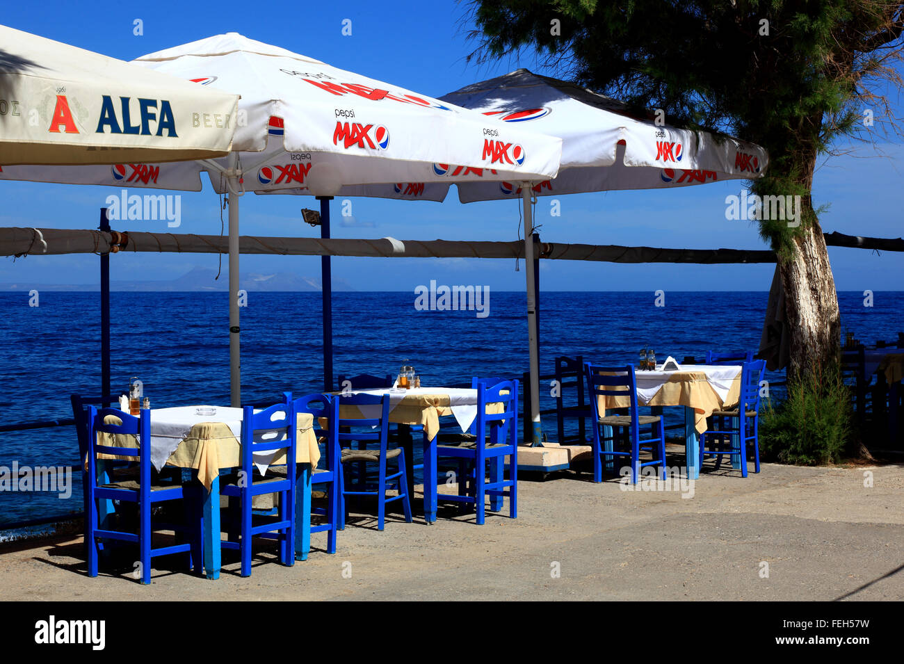 Crète, Rethymnon, street restaurant à regarder la mer, le bleu des chaises, tables et parasols Banque D'Images