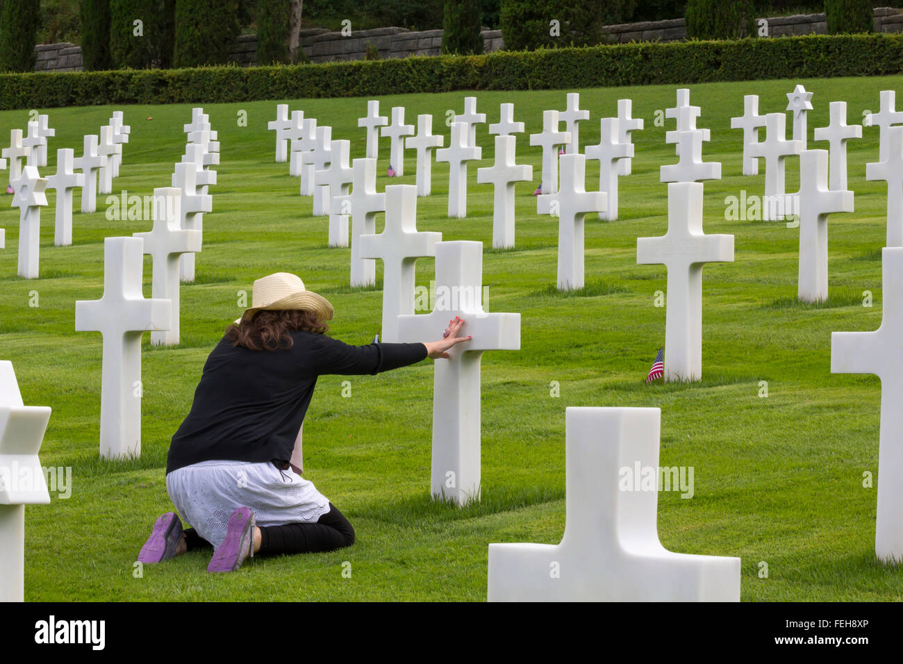 Femme en prière dans un cimetière commémoratif des soldats pour la guerre, Banque D'Images