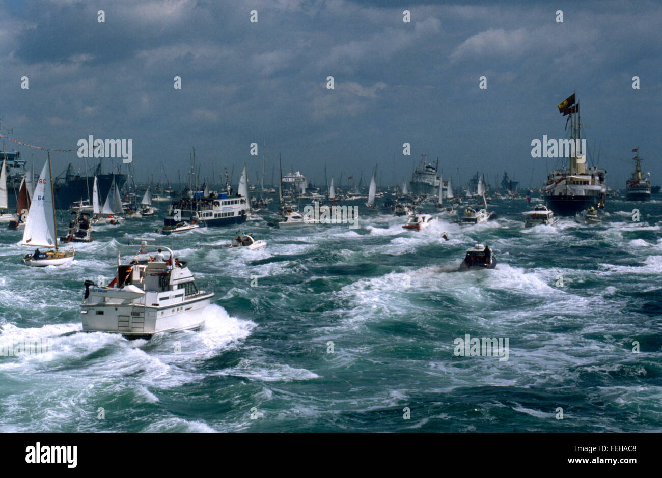 AJAXNETPHOTO - JUIN, 1994. SPITHEAD, Angleterre. Avis sur l'ANNIVERSAIRE DE LA REINE - Flotte - le yacht royal Britannia L'ACCOMPLISSEMENT DE SA MAJESTÉ LA REINE, VOILES MAJESTUEUSEMENT À TRAVERS LA FLOTTE RÉUNIE POUR L'EXAMEN SUR LE SOLENT suivie par une flottille de bateaux de plaisance. PHOTO;JONATHAN EASTLAND/AJAX REF:402823 Banque D'Images