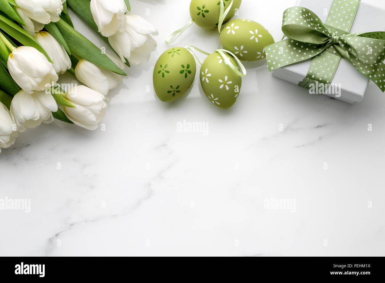 Oeufs de Pâques,tulipes et boîte-cadeau sur le marbre blanc Banque D'Images