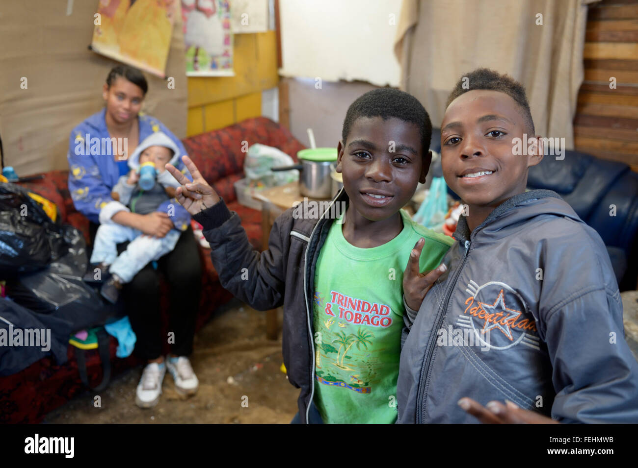 Deux garçons, 12 et 11 ans, et jeune femme avec bébé dans un camp de fortune pour réfugiés de guerre civile, Barrio Bello Horizonte, Bogota Banque D'Images