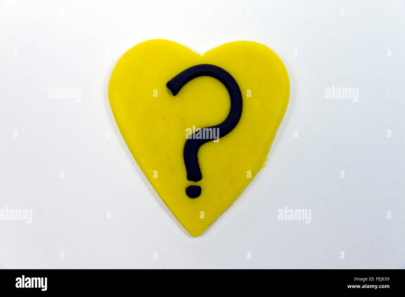 Coeur jaune avec un point d'interrogation fait de Play-doh. Banque D'Images