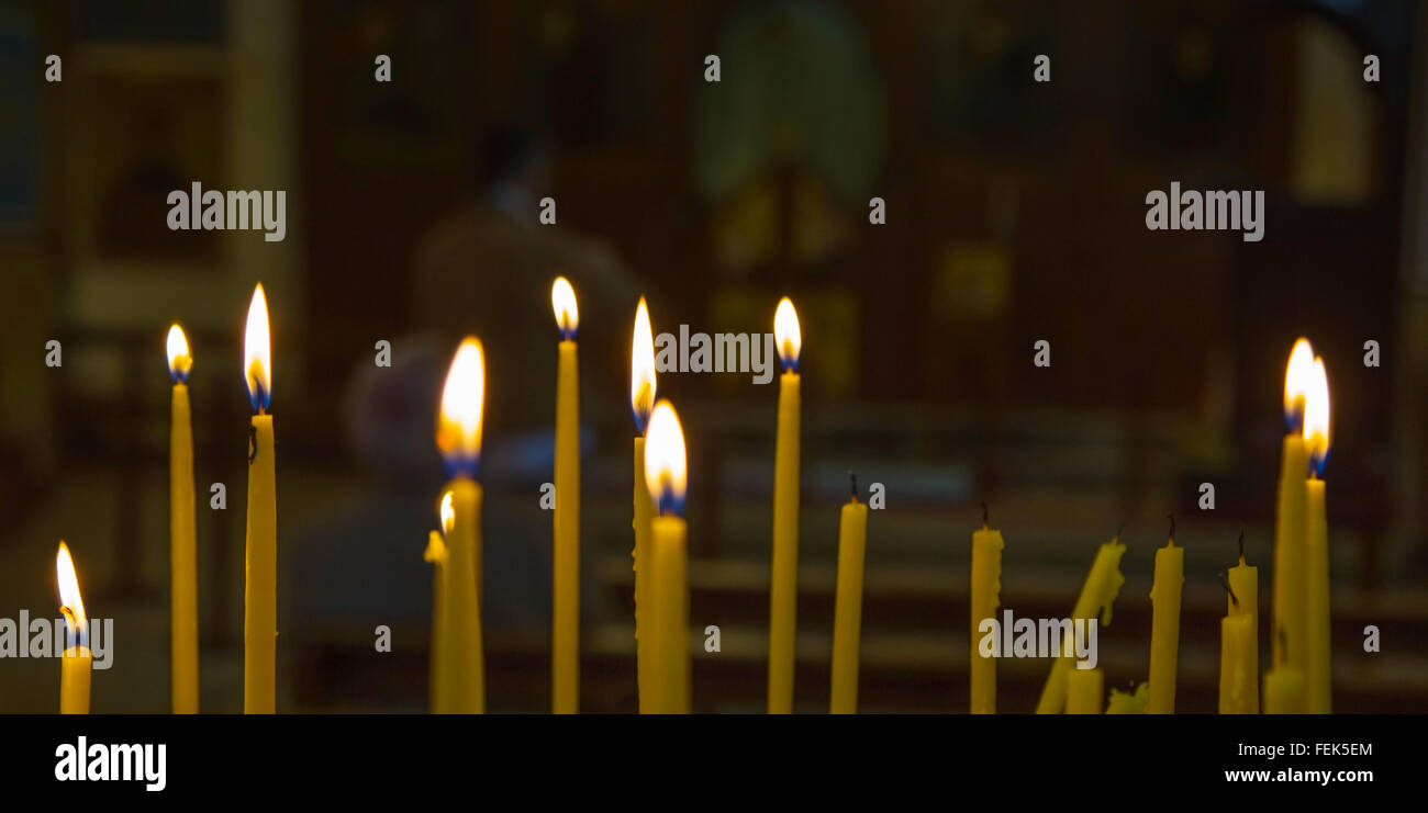 Bougies allumées dans une église qui brûle dans le crépuscule Banque D'Images