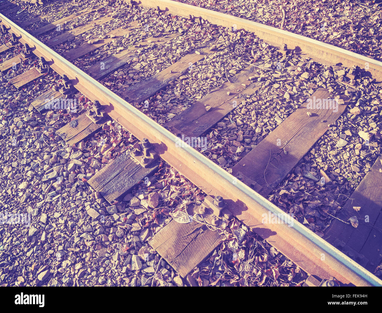 Retro photo filtrée de voies de chemin de fer avec des traverses en bois. Banque D'Images