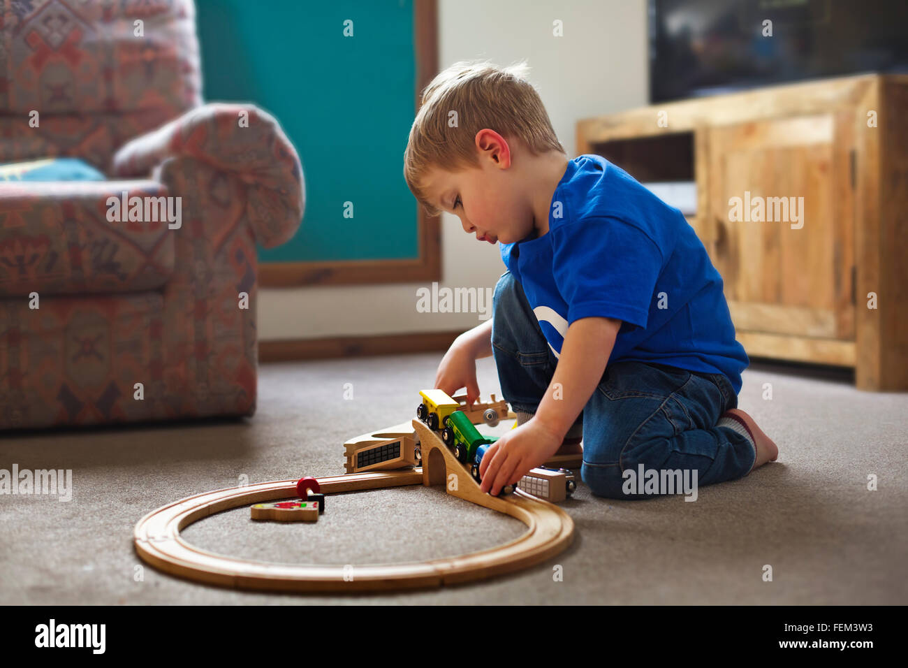 Un petit Garçon jouant avec un jeu de train Banque D'Images