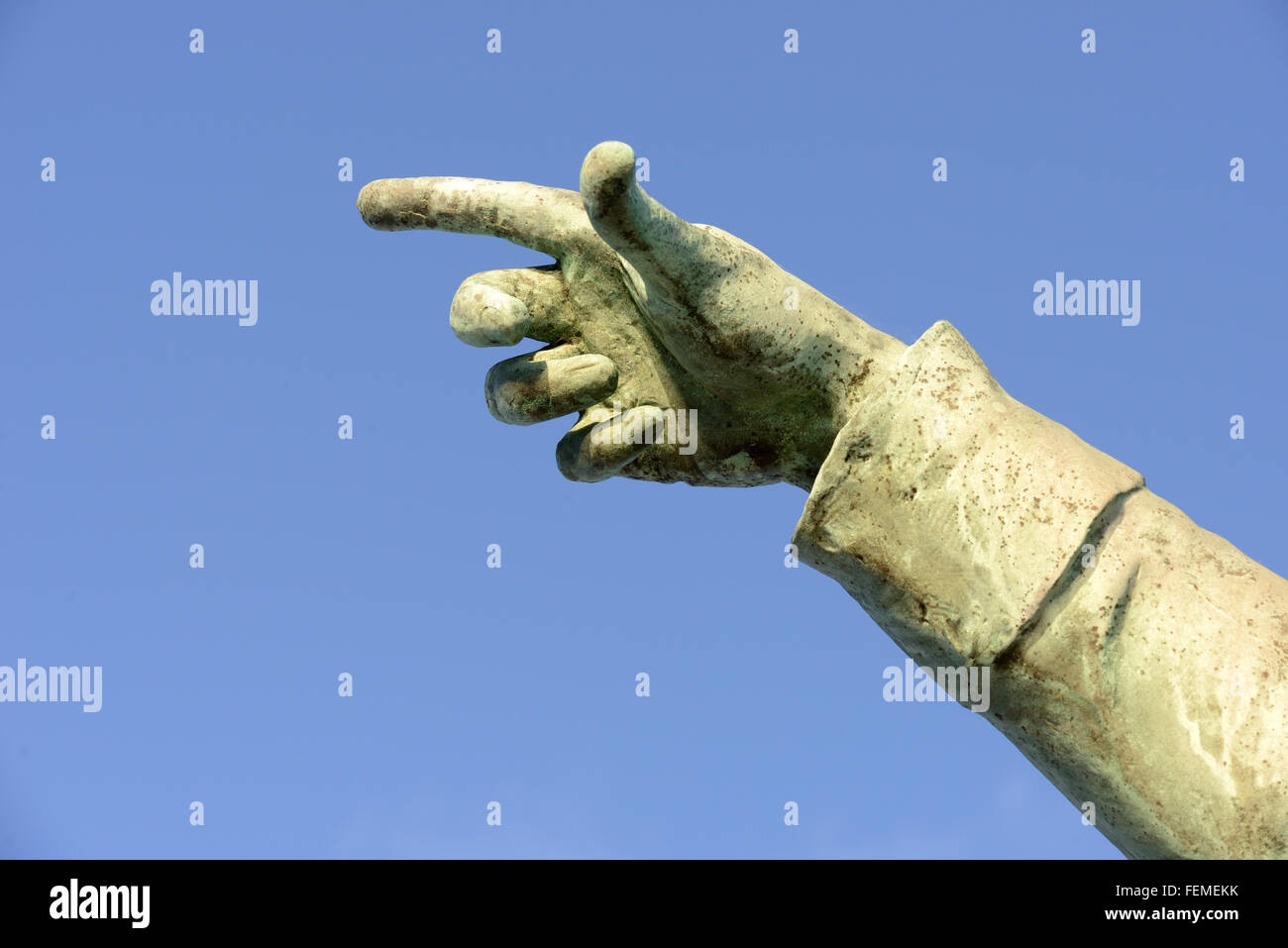 Une statue de pierre part avec le doigt pointant sur un fond de ciel bleu Banque D'Images