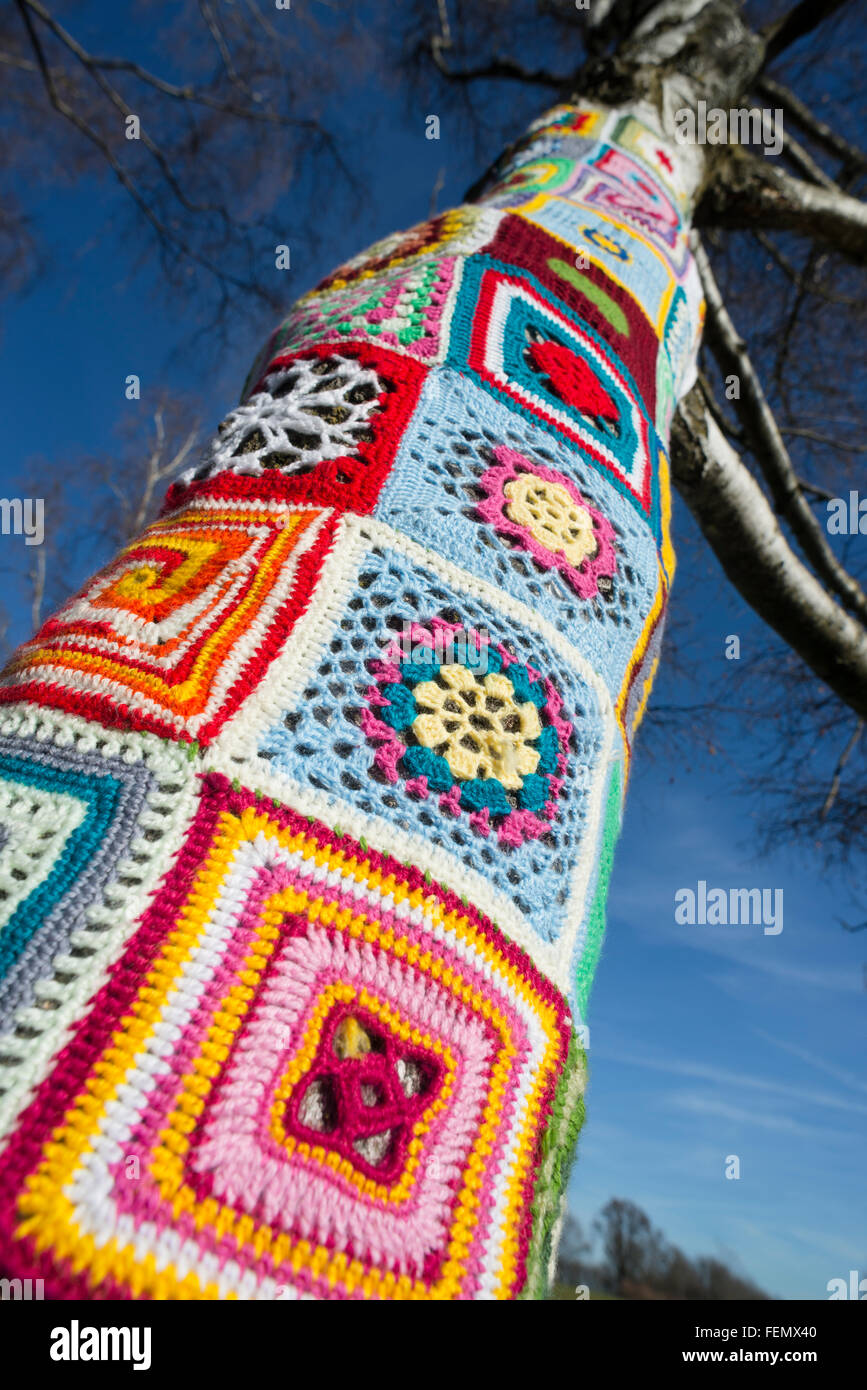 Gros plan de guérilla - tricot laine colorée autour de modèles un tronc d'arbre dans l'Olympiapark de Munich, Allemagne Banque D'Images