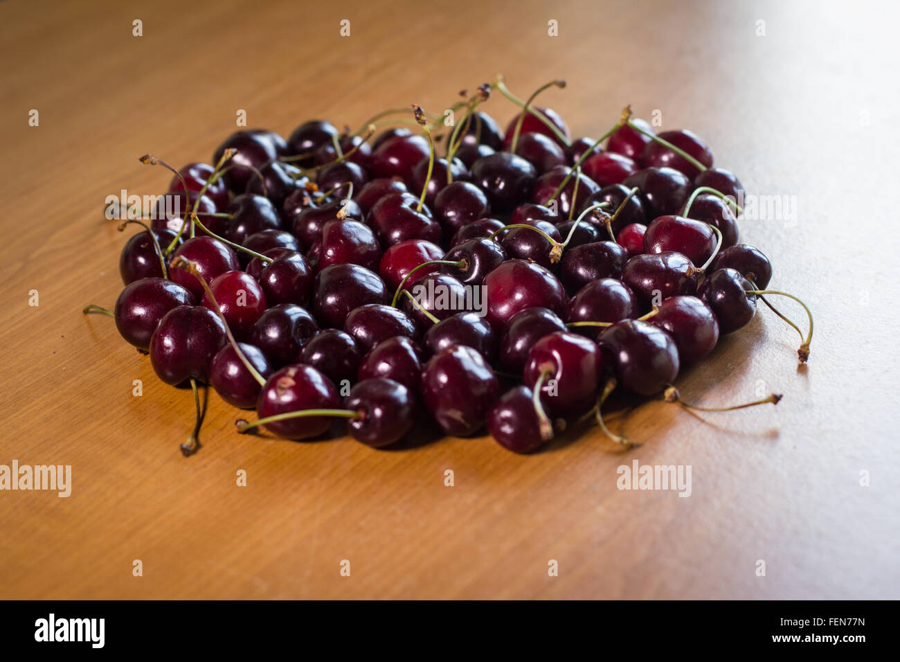 Cercle fait avec des cerises mûres sur table en bois Banque D'Images