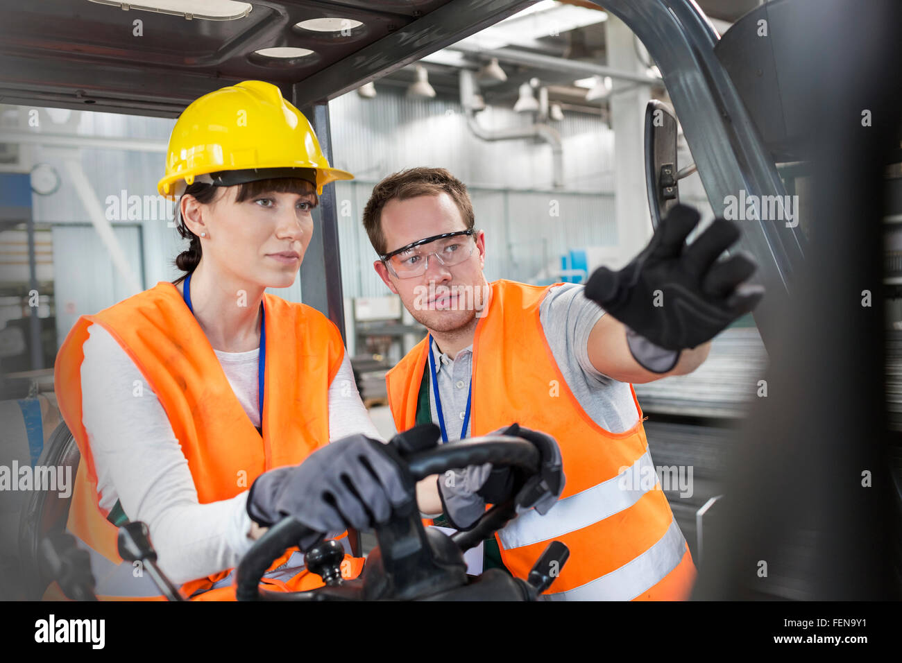 Directeurs travailleur collègue driving forklift in factory Banque D'Images