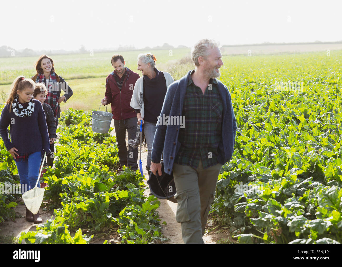 Multi-generation family walking in sunny potager Banque D'Images