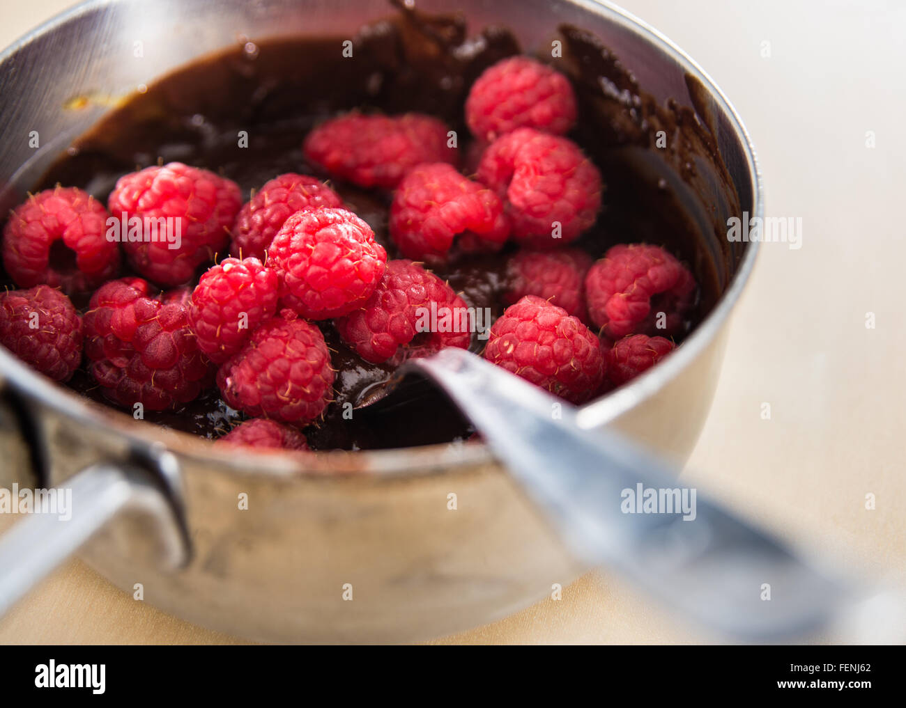 Sauce au chocolat avec des framboises dans une petite casserole Banque D'Images