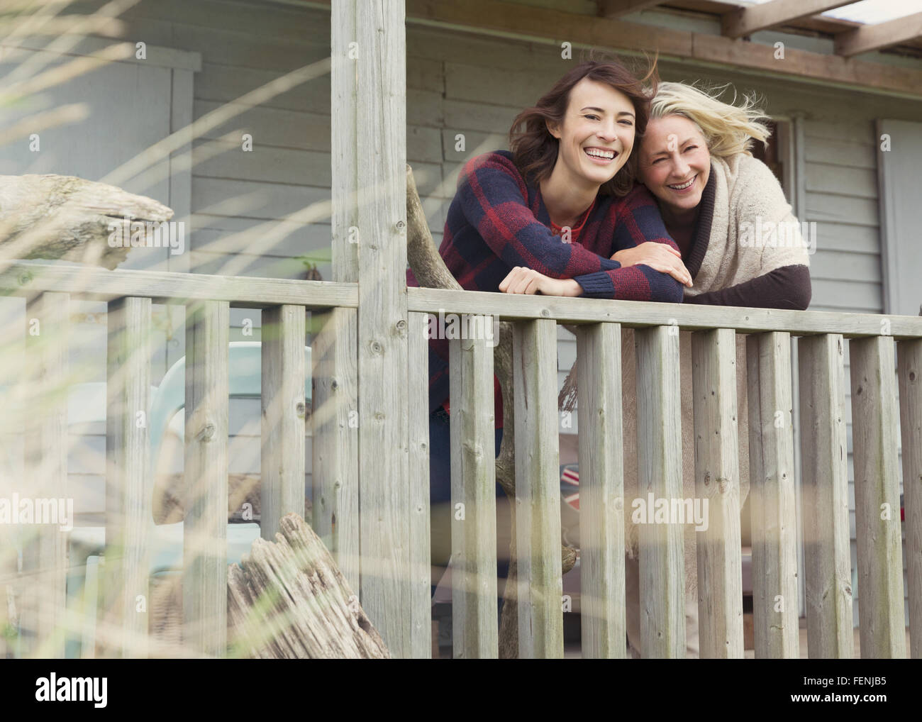 Portrait of smiling mother and daughter on porch Banque D'Images